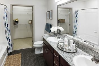 A bathroom with a toilet, sink, and mirror.